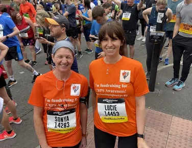 Two ladies wearing orange t-shirts after a run