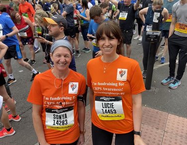 Two ladies wearing orange t-shirts after a run