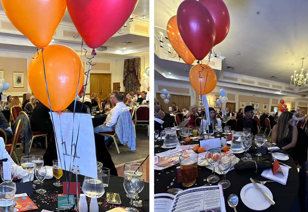 Image shows attendees sitting at their tables during the fundraising event