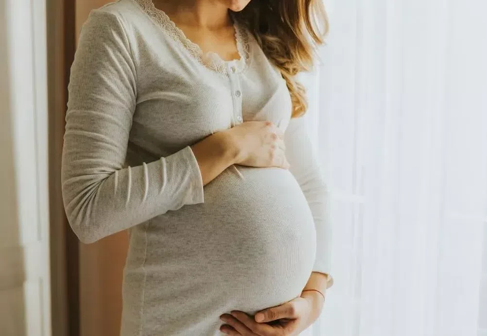 A pregnant woman cradling her bump