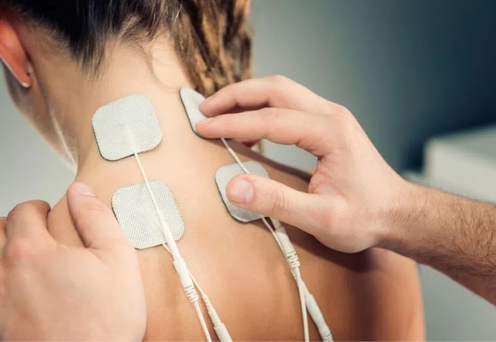 TENS pads placed on the back of a woman's neck