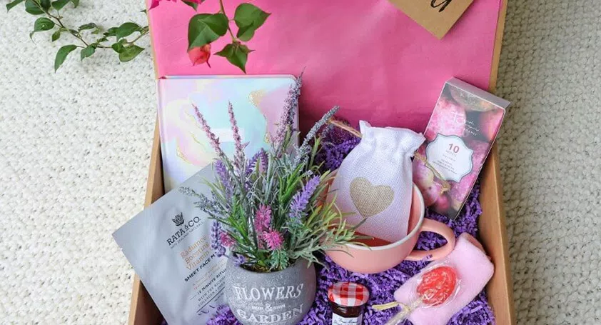 Image of a gift box containing a: mug, pot, sweets, face masks, diary and jam