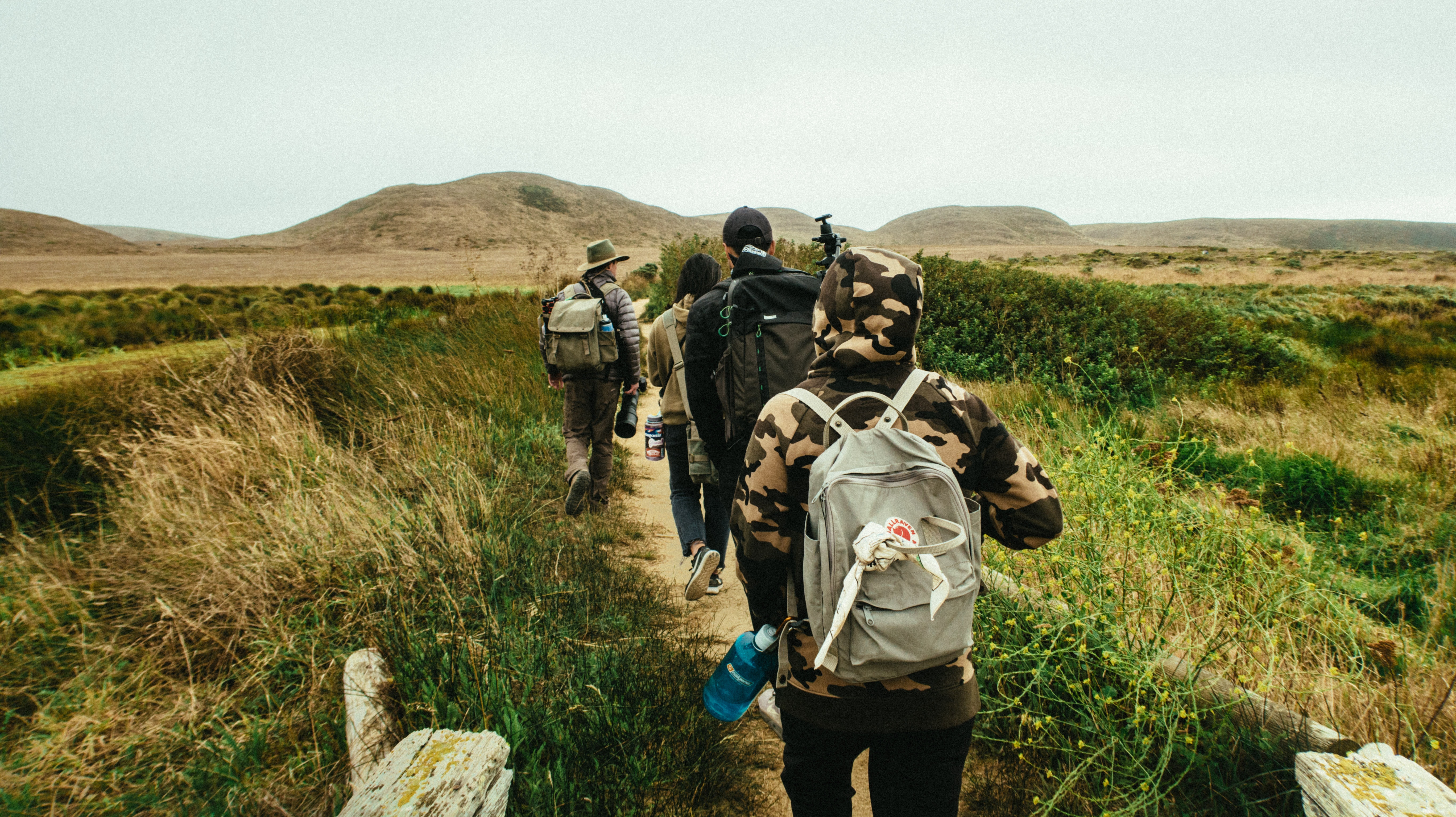 People in camouflage clothing walking along trail