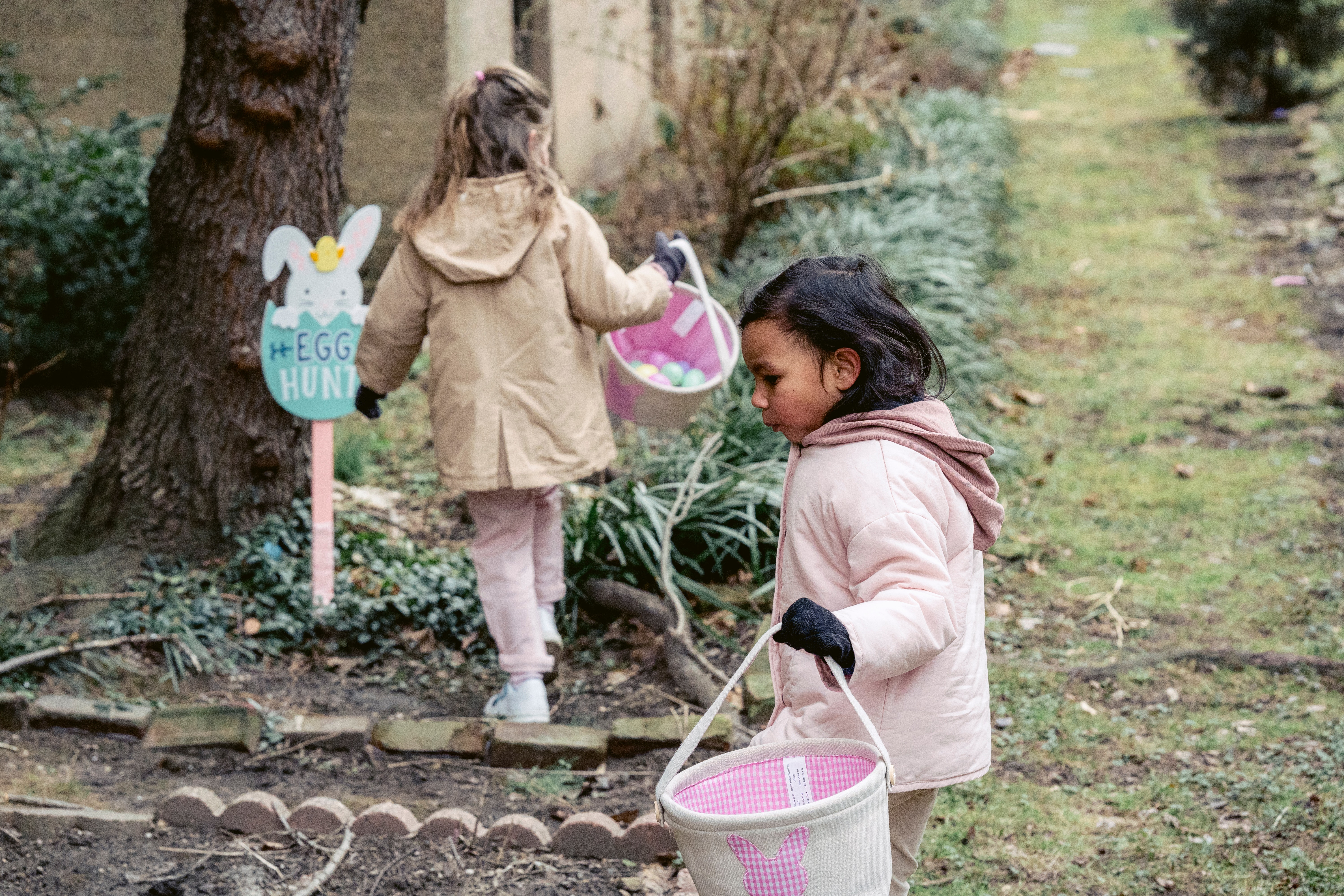 Two little girls hunting for easter eggs