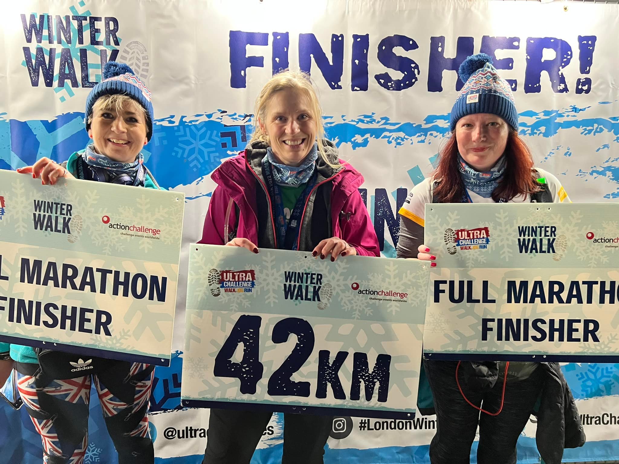 London Winter Walk 2026, photo of finishers with signs that say "42km" and "full marathon finisher"