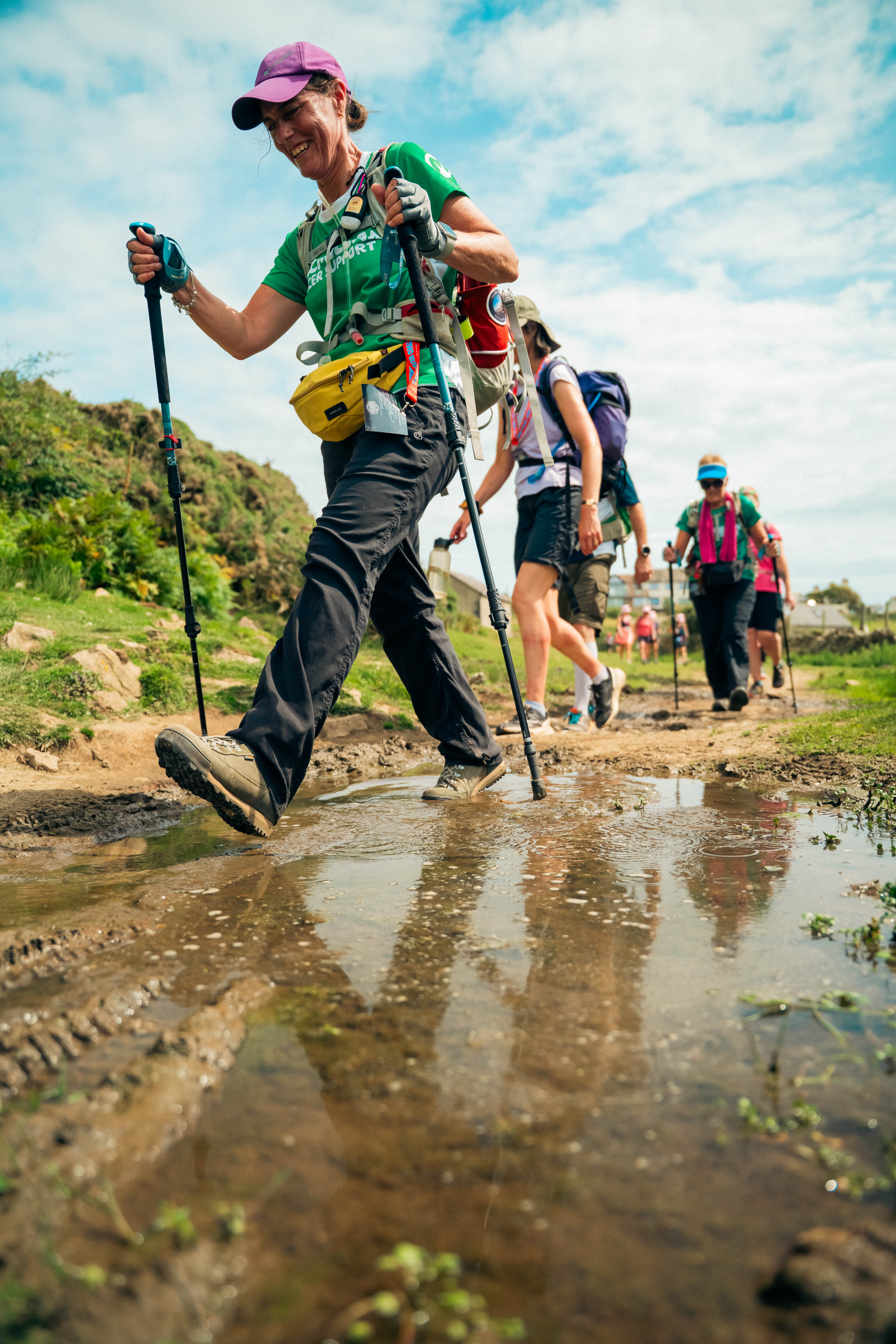 Peak District Ultra Challenge 2026, photo of participants on the route walking through a muddy puddle with smiles on their faces