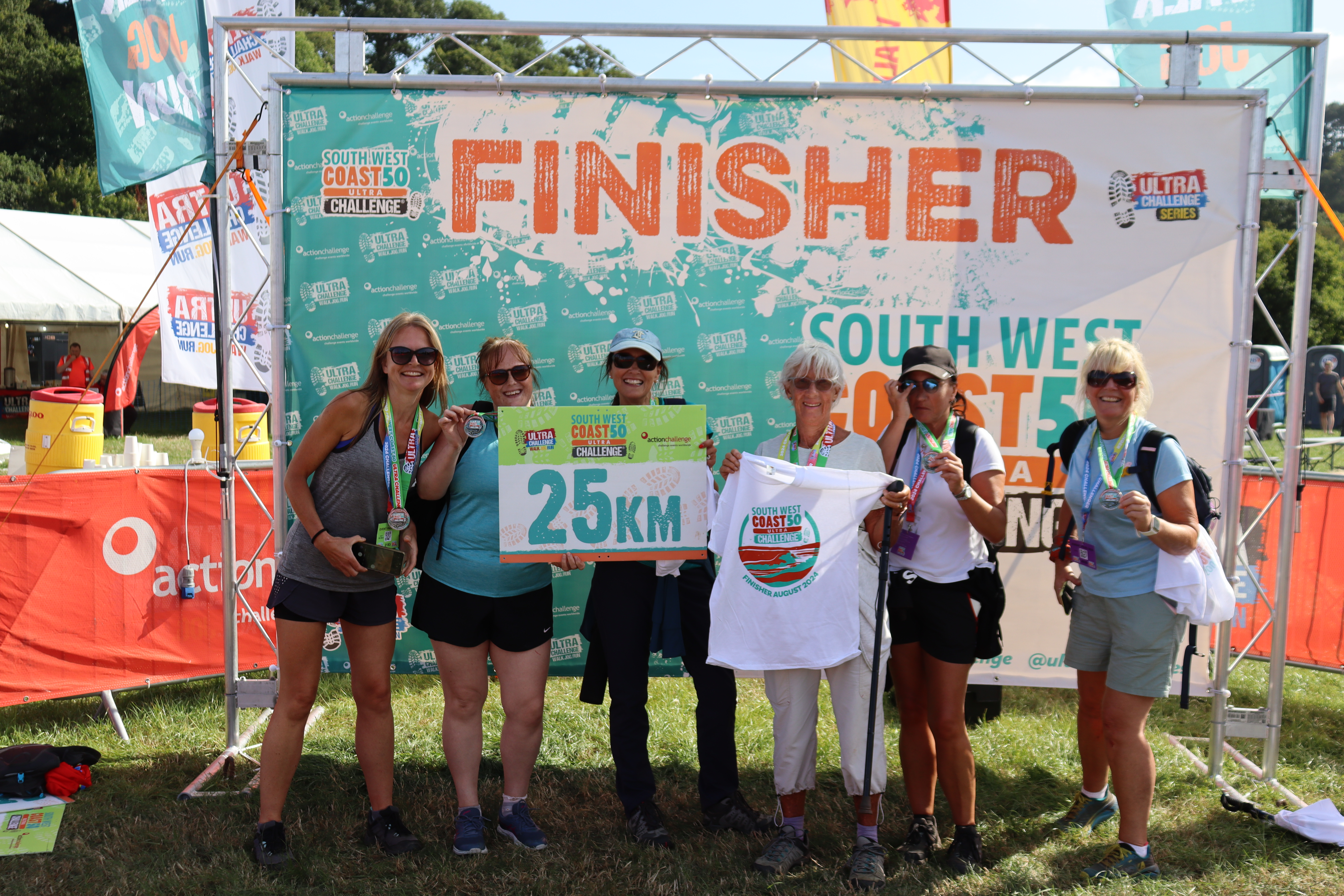 South West Coast 50 Ultra Challenge 2026, photo of participants at the finish line holding a sign that says "25km"