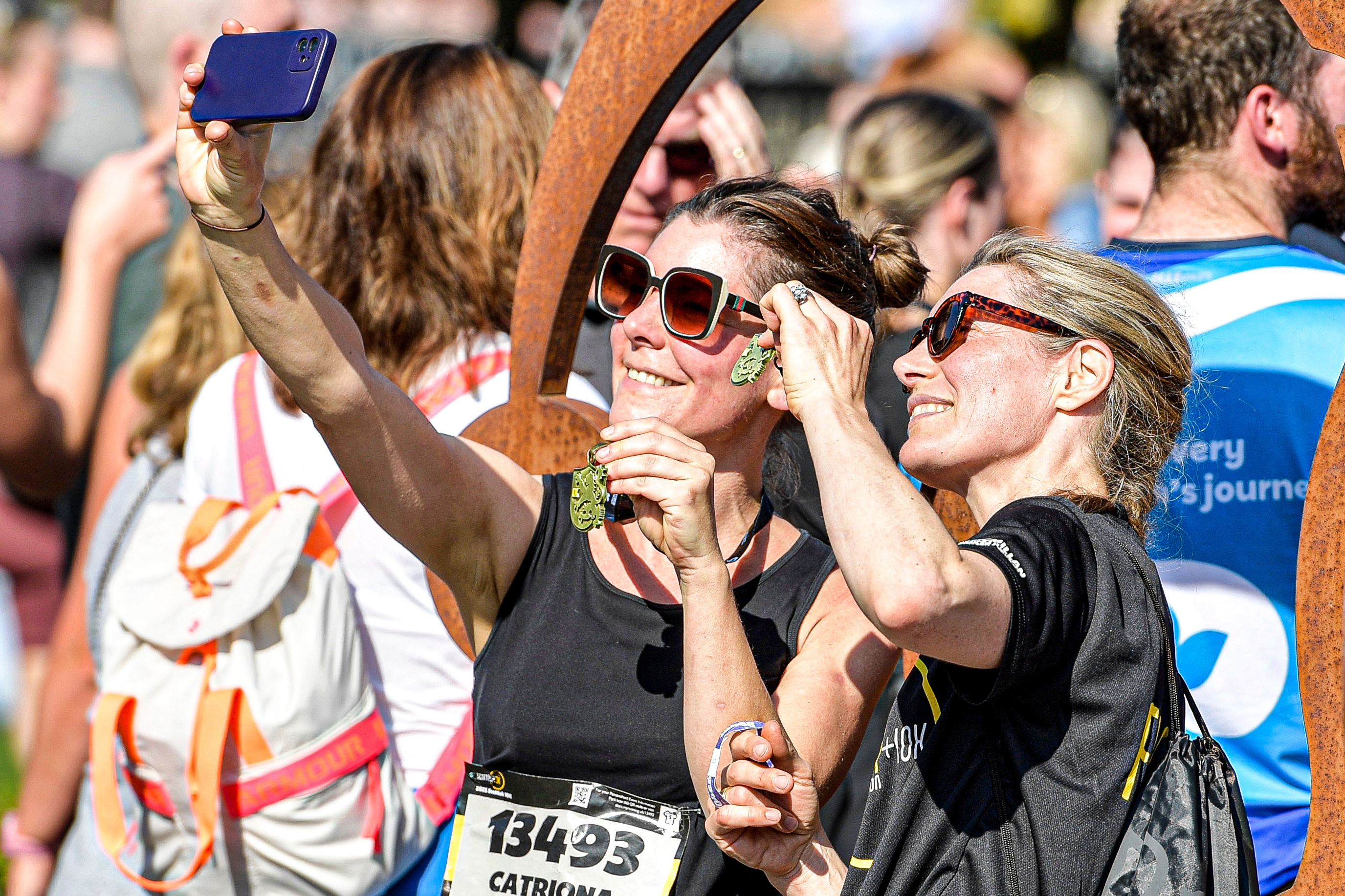 2026 Scottish 10K, photo of event two participants wearing sunglasses, taking a selfie whilst smiling and posing with their finisher medals