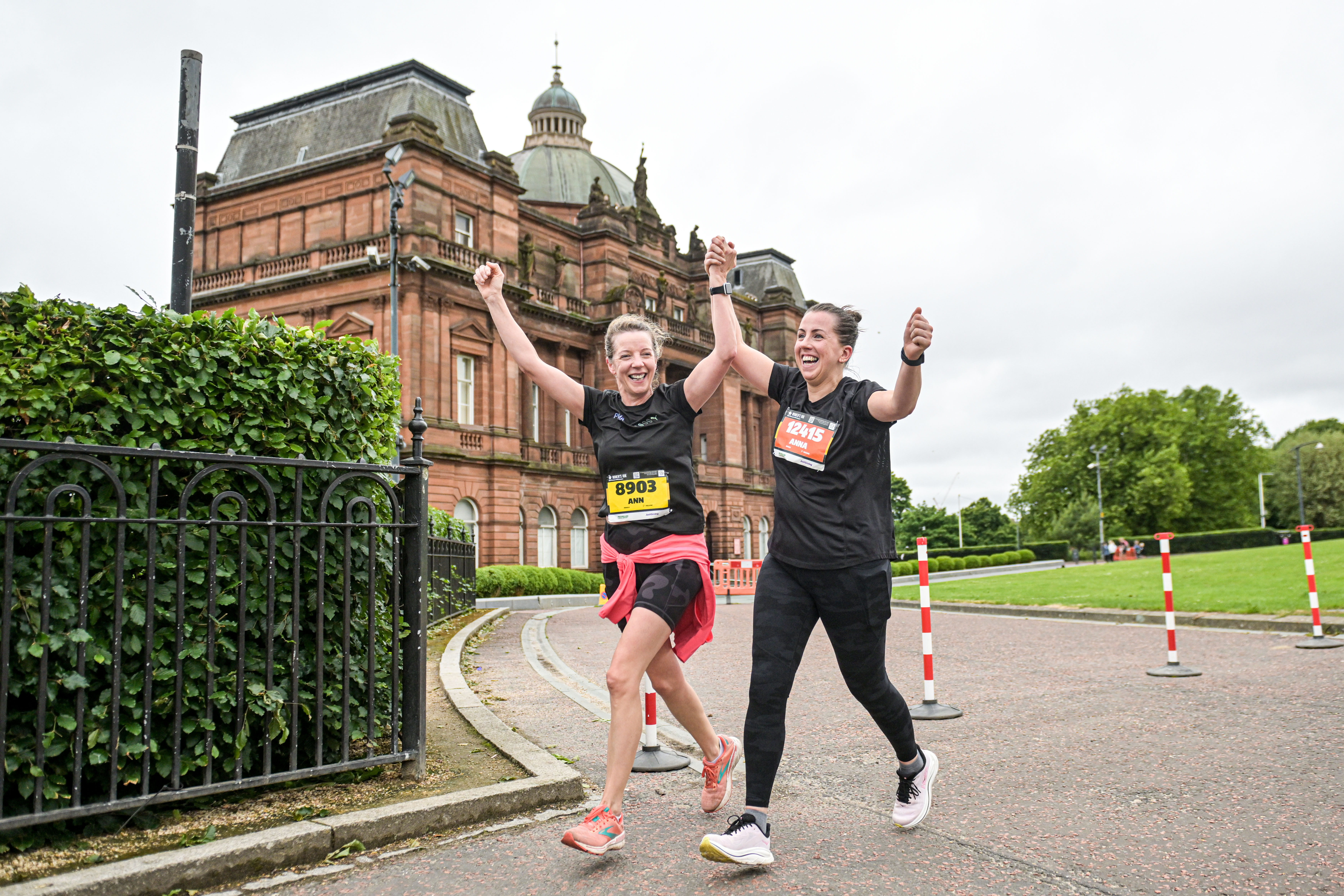 2026 Women’s 10K Glasgow, photo of two event participants smiling and holding hands as they run along the event route