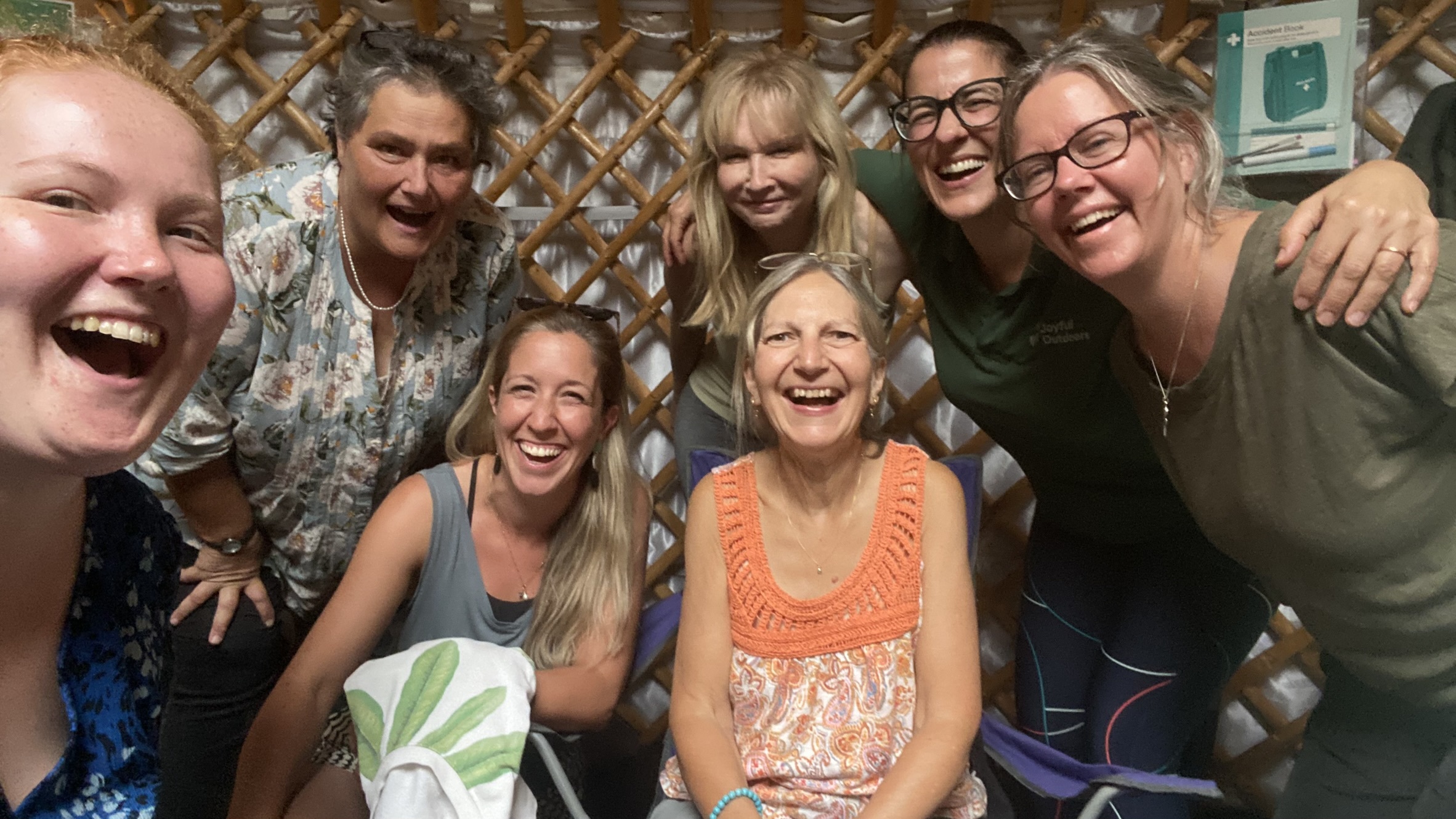 Laughter Yoga, photo of a group of people smiling and laughing whilst looking at the camera
